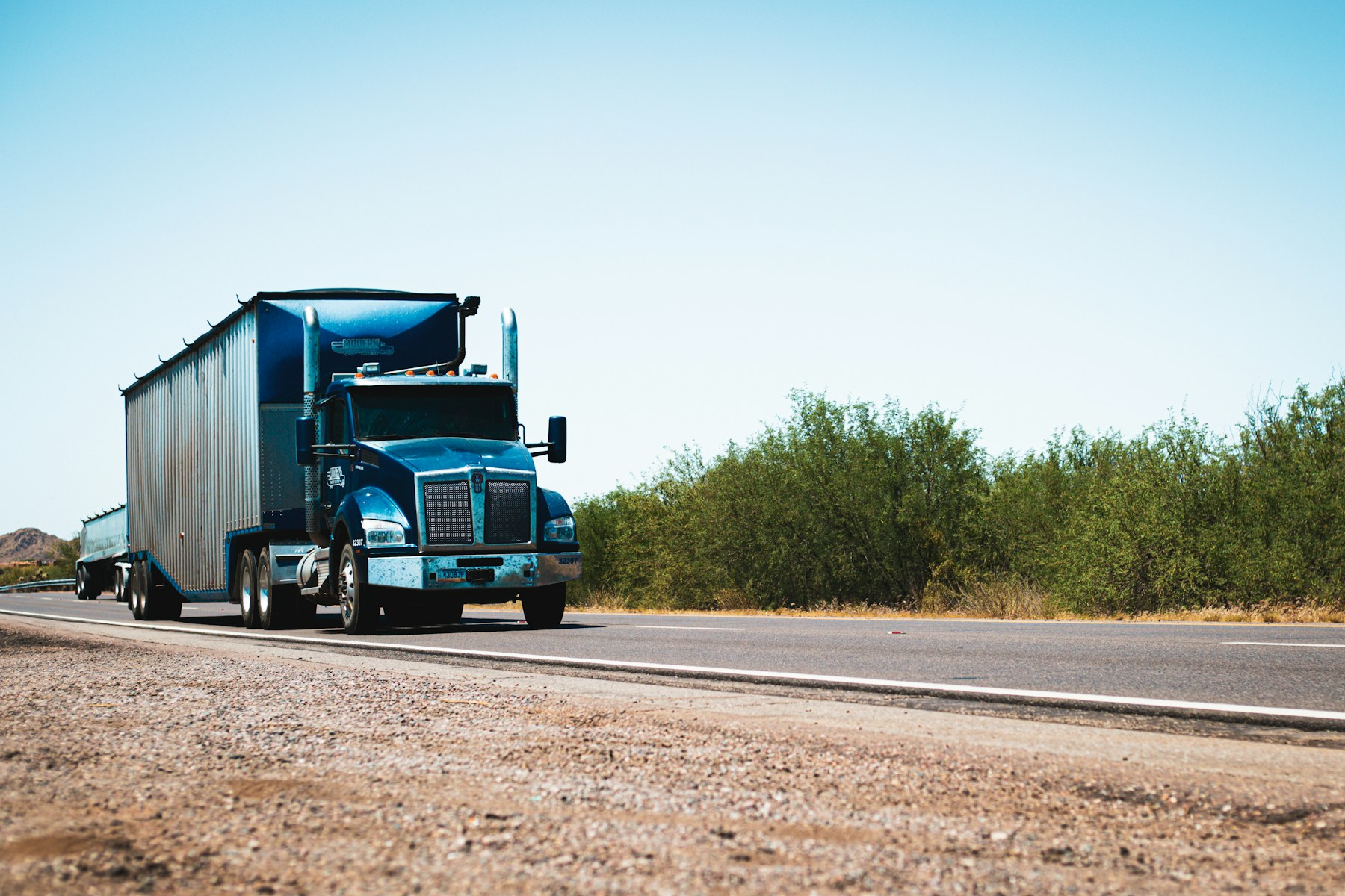 Blue semi-truck traveling on an open highway