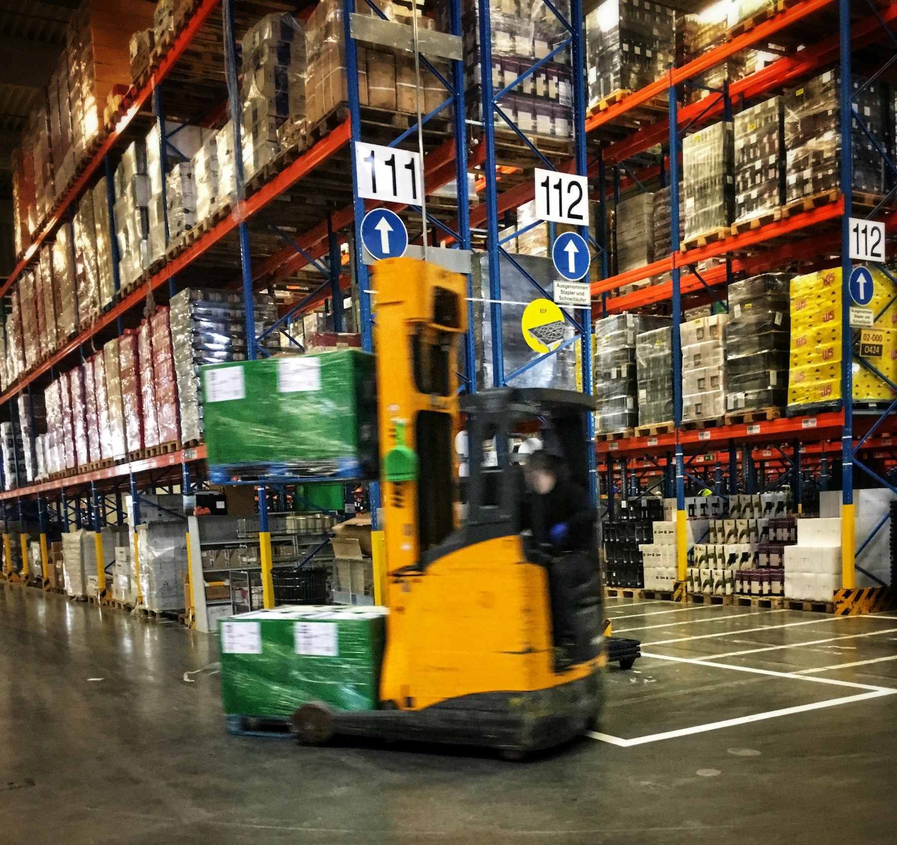 Forklift moving palletized freight inside a warehouse